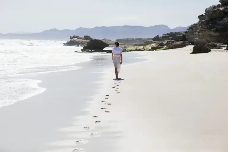 Addiction to Pain Medication - A Silent Struggle - female walking along the beach